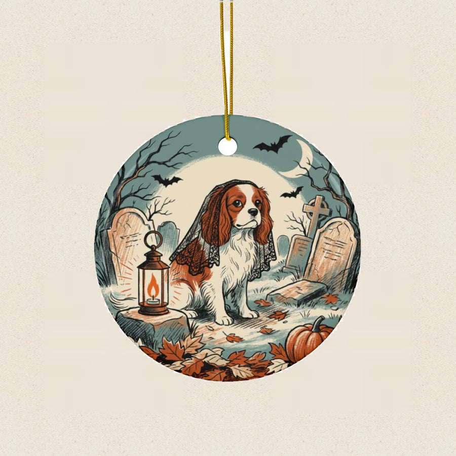 Cavalier King Charles Halloween Poster Ceramic Tree Ornament round ceramic ornament by Tritan, laid flat on a warm limestone surface