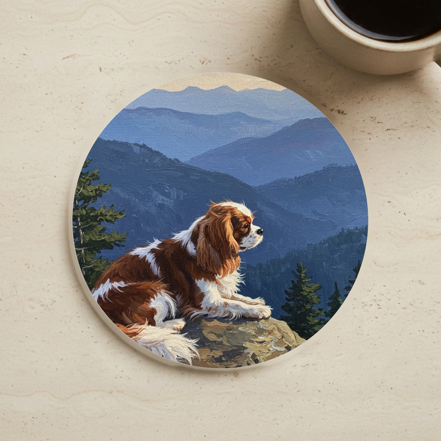 Acrylic Painting Cavalier King Charles Spaniel - Mountain Overlook cork coaster shown on a warm limestone surface beside a mug