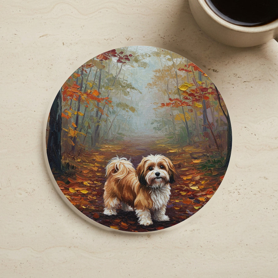 Acrylic Painting Havanese - Autumn Woods cork coaster shown on a warm limestone surface beside a mug
