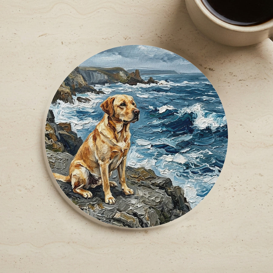 Acrylic Painting Labrador Retriever - Coastal Cliffside cork coaster shown on a warm limestone surface beside a mug