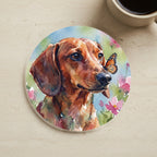 Dachshund Watercolor Butterfly Bloom Drink Coaster cork coaster shown on a warm limestone surface beside a mug