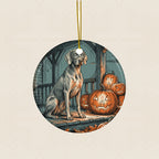 Weimaraner Halloween Poster Ceramic Tree Ornament round ceramic ornament by Tritan, laid flat on a warm limestone surface