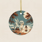 Maltese Halloween Poster Ceramic Tree Ornament round ceramic ornament by Tritan, laid flat on a warm limestone surface