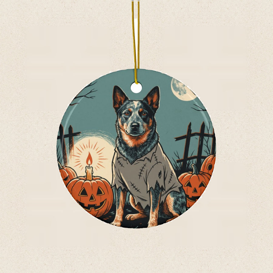 Australian Cattle Dog Halloween Poster Ceramic Tree Ornament round ceramic ornament by Tritan, laid flat on a warm limestone surface