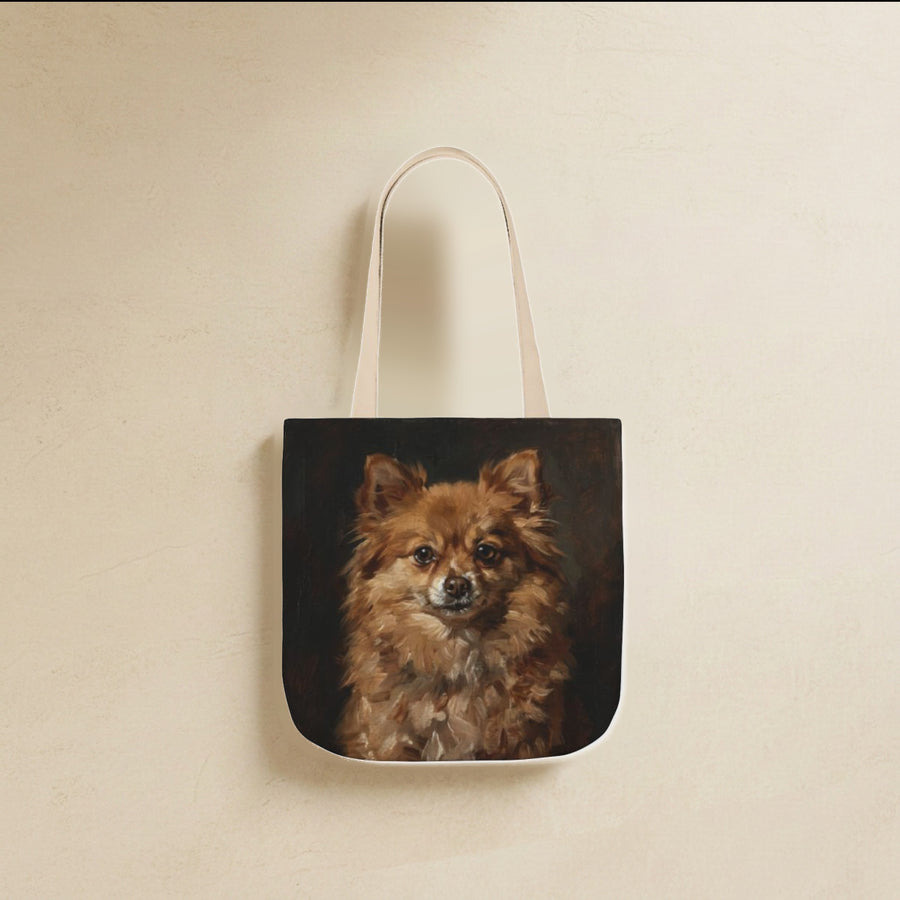Pomeranian Tote Bag canvas tote bag hanging by its handles against a warm limestone wall